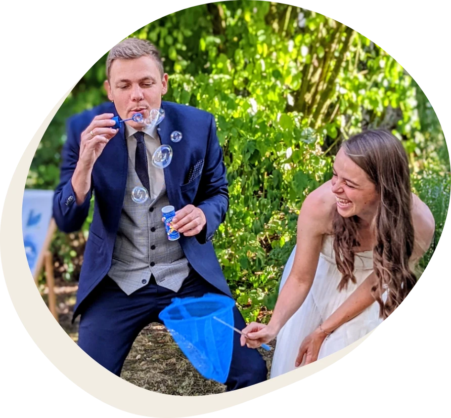 Ein Ehepaar lacht zwischen Seifenblasen.