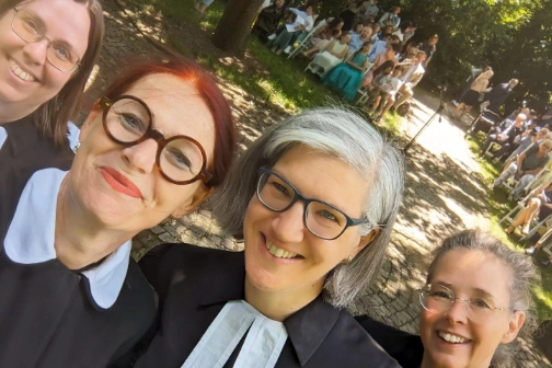 Pfarrerinnen im Freien bei einem Tauffest.